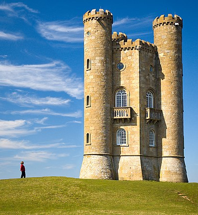 Green grass, on top of it a person in the left, a tower in the right and sky with a few clouds in
the background and middle. The sky is significantly narrower than previous picture.