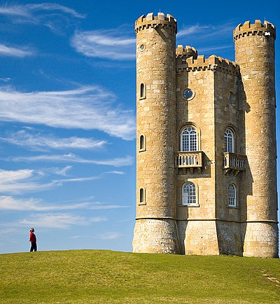 Green grass, on top of it a person in the left, a tower in the right and sky with a few clouds in
the background and middle. The sky is significantly narrower than previous picture. But the tower is
cut too from both sides.